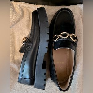 Black dress shoe with gold chain accent-